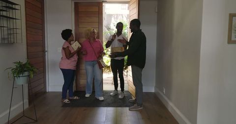 Friends Sharing Joy and Gifts in Warm Home Welcome