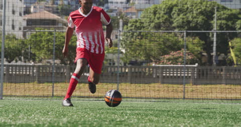 Soccer Player Dribbling on Sunny Field in Intense Training