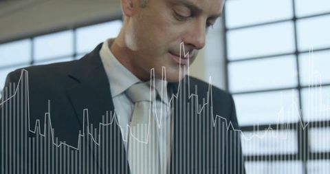 Executive analyzing financial bar and line graphs overlay in sunlit office with grid windows