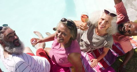 Senior Friends Toasting by the Pool During Relaxed Gathering