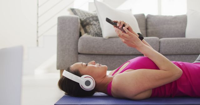 Woman Relaxing on Yoga Mat with Smartphone and Headphones - Download Free Stock Images Pikwizard.com