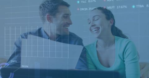Couple reviewing finances with stock market overlay