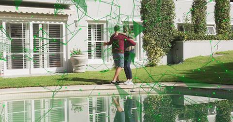 Mature couple embracing by pool with green digital network overlay and backyard reflection