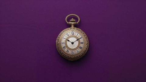 Elegant british empire ornate pocket watch on rich purple background