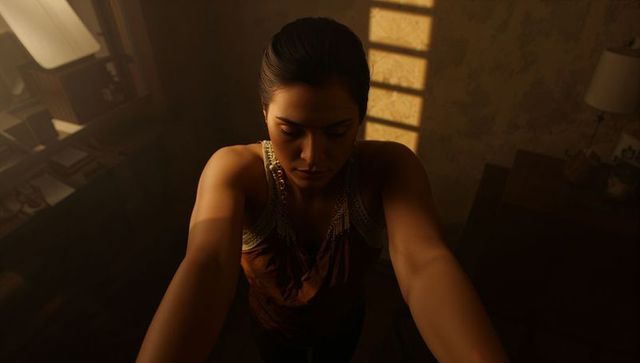 Reaching woman in low light bedroom with dramatic window shadows and intimate mood