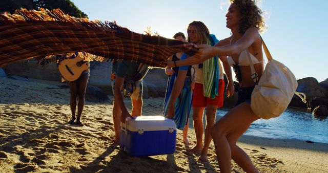 Friends Setting Up Blanket on Beach for Relaxed Afternoon - Download Free Stock Images Pikwizard.com