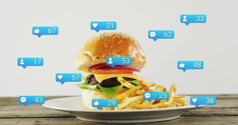 Social media notifications surrounding cheeseburger with fries on rustic table