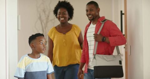 African american family walking into home with smiling parents and thoughtful child