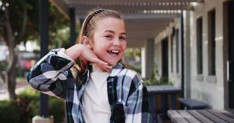 Youthful Girl in Plaid Posing Outdoors with Picnic Tables