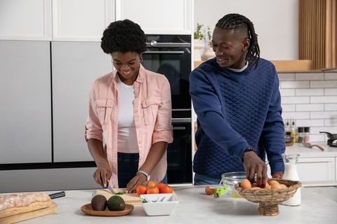African American Couple Enjoys Home Cooking Together in Modern Kitchen
