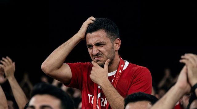 Disappointed turkish football fan holding head and touching chin during crucial match