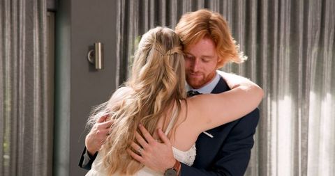 Joyful newlywed couple dancing in modern living room