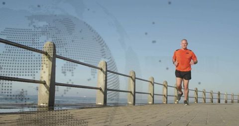 Active senior man jogging at seaside with global technology overlay