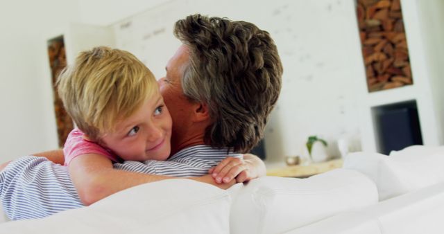 Father and Son Embracing on Couch in Modern Living Room - Download Free Stock Images Pikwizard.com