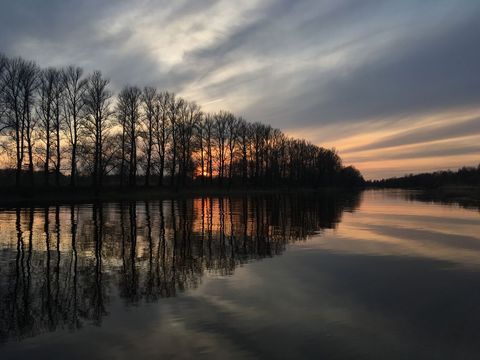 Serene Lake with Dramatic Sunset and Reflective Trees