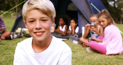 Smiling Boy Enjoying Camping Adventure with Friends