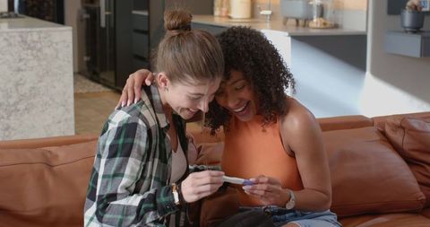 Happy partners embracing positive pregnancy test moment