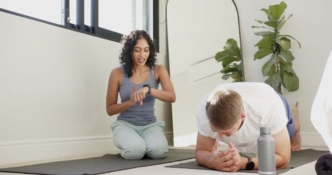 Diverse Duo Engaged in Home Fitness with Modern Technology
