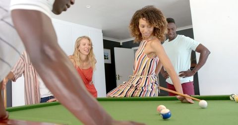 Diverse group celebrating pool game victory at home