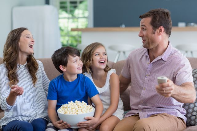 Family watching tv and eating popcorn in living room at home - Download Free Stock Photos Pikwizard.com