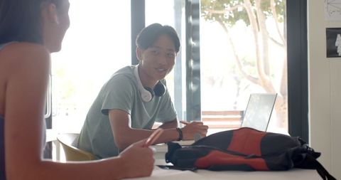Teenager studying with laptop in classroom environment