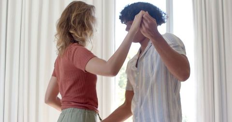Romantic couple dancing in sunlit room embracing intimacy