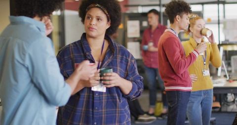 Casual office break with diverse colleagues sharing coffee