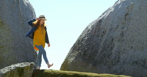 Young woman navigating sunny rocky terrain