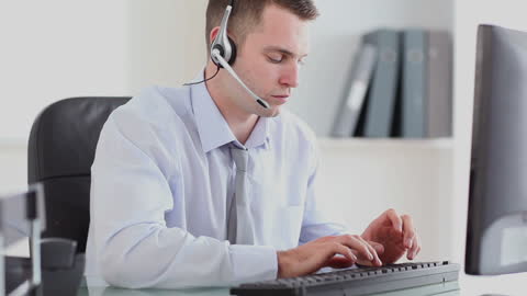 Dedicated Customer Support Agent Typing at Desk in Modern Office