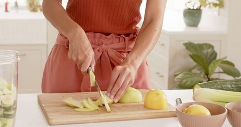 Woman Preparing Fresh Pear in Modern Home Kitchen