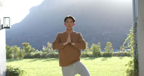 Man Practicing Tree Pose Outdoors Near Mountain View