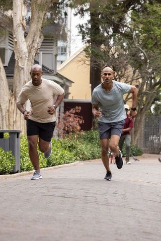 Male runners sprinting on neighborhood path during outdoor fitness training session