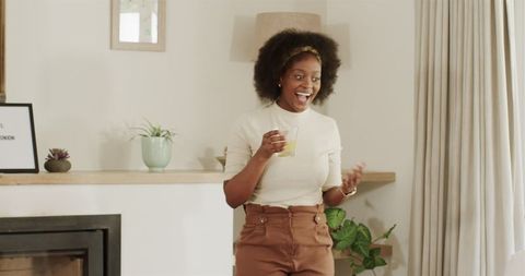 Joyful Woman Enjoying Beverage in Cozy Living Area