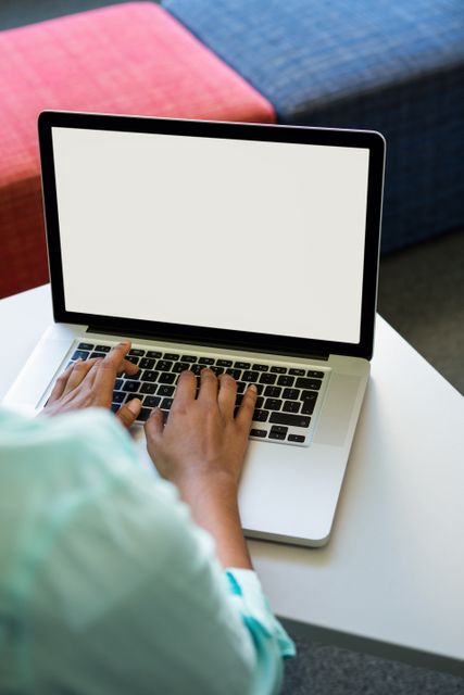 Cropped image of woman using laptop in library