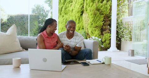 Happy Couple Discussing Finances at Home with Laptop