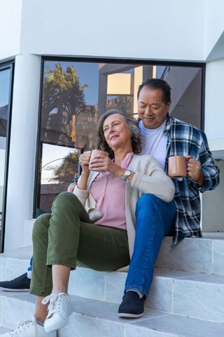 Senior Couple Enjoying Morning Coffee on Stone Steps