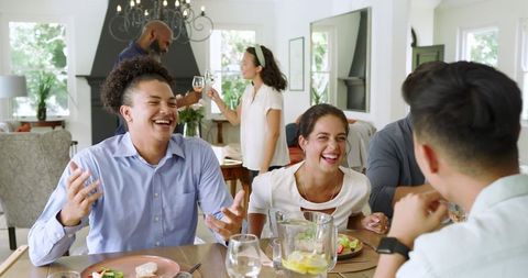 Friends enjoying laughter and food at home gathering