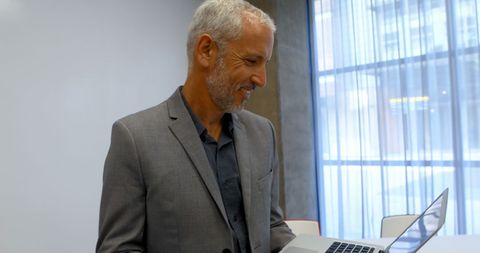 Businessman Working on Laptop Ensures Productivity in Office Environment