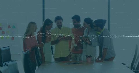 Young team collaborating around smartphone, studying ideas and sharing feedback