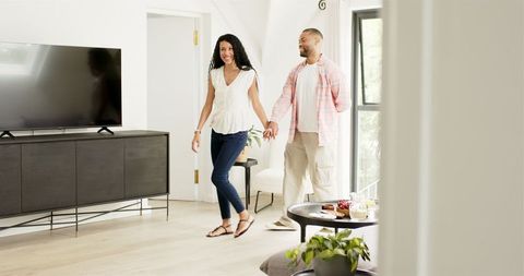 Man Proposing at Home with Engagement Ring to Smiling Woman