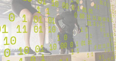 Dynamic plyometric box jump partners in industrial gym with rings and brick wall