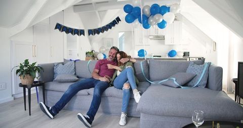 Happy Couple Celebrating Birthday at Home with Balloons
