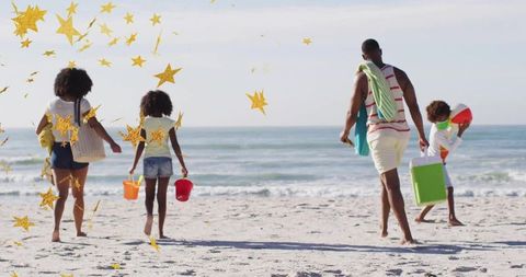 Family enjoying vibrant beach day carrying supplies