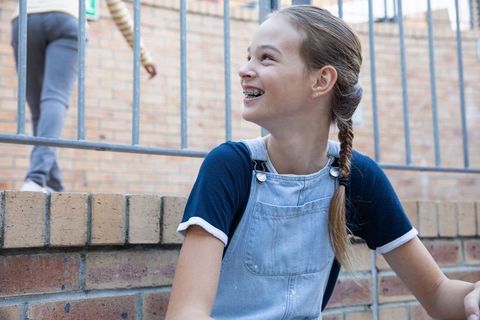 Joyous Teenage Girl Relaxing Outside in Schoolyard