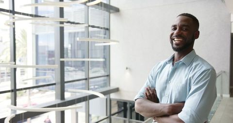 Confident Businessman Smiling in a Modern Office Building Atrium