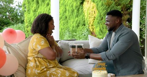 Happy Couple Celebrating Anniversary with Gifts and Cake Outdoors