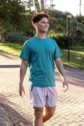 Man walking on serene park path during day