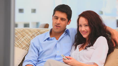 Couple Relaxing on Sofa Watching TV Together