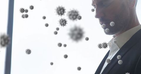 Businessman using smartphone around flu virus particles airborne