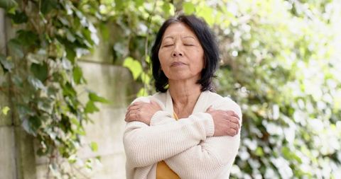 Senior Woman Enjoying Serenity in Leafy Garden Setting
